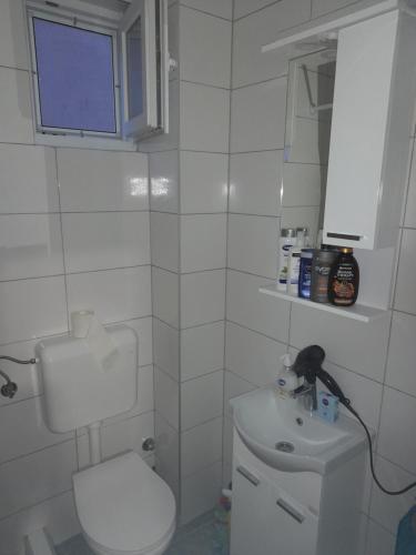 een witte badkamer met een toilet en een wastafel bij Markov Konak in Foča