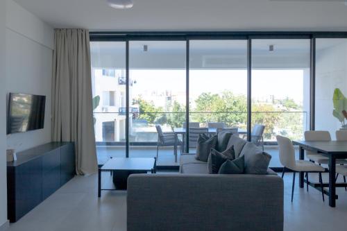 una sala de estar con un sofá y una mesa en Phaedrus Living White Hills Suites Panoramic View, en Aglantzia