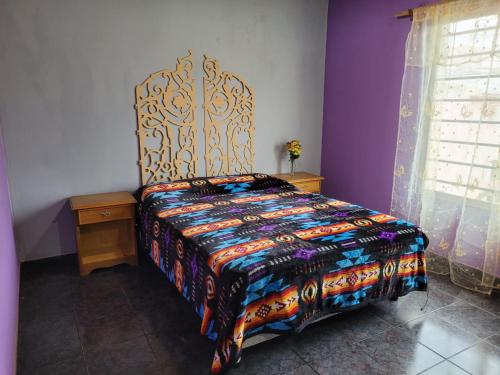 a bedroom with a bed with a colorful bedspread at Amplio departamento para 2 personas in Neuquén