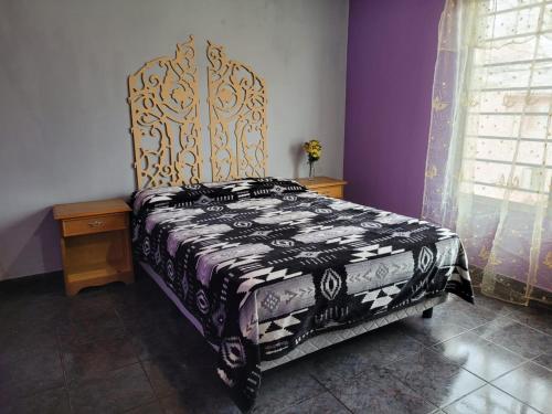 a bedroom with a bed with a black and white blanket at Amplio departamento para 2 personas in Neuquén