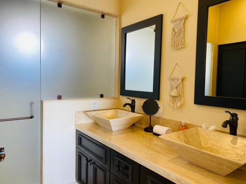 a bathroom with two sinks and a mirror at Casa Paradiso Copala Private Home in Quivira Community in Cabo San Lucas