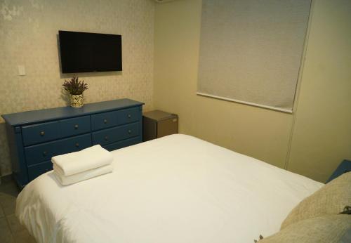 a bedroom with a white bed and a blue dresser at Hostal 53 Boutique Santo Domingo in Santo Domingo