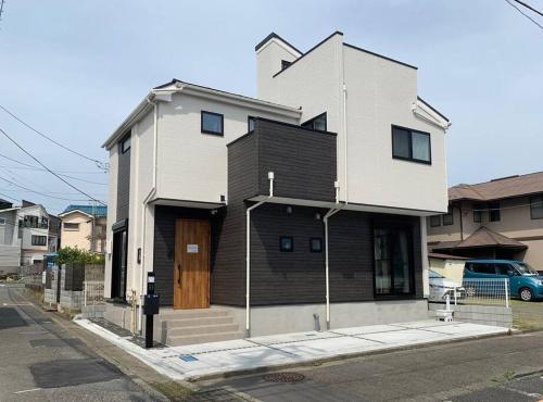 a house with a wooden door on a street at 鎌倉 Sea Home in Koshigoe