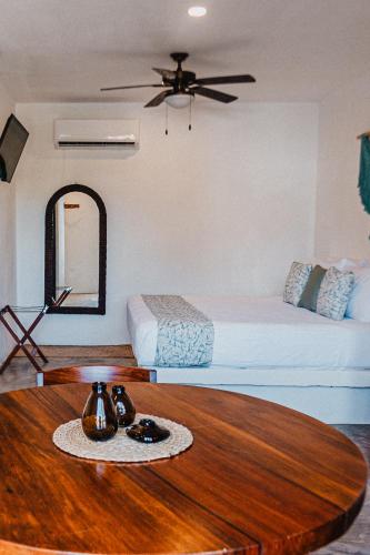 a room with a bed and a wooden table with a coffee table sidx sidx sidx at HAU Holbox, Oceanfront Boutique Hotel in Holbox Island