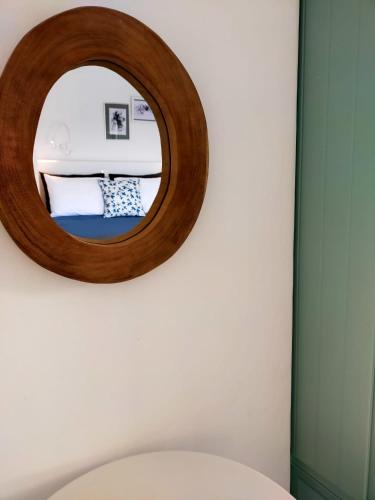 a mirror on a wall above a toilet at Amorgos Elegant Houses, Villa 3 in Aegiali