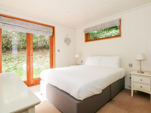 a bedroom with a large white bed and a window at Harley's House in Oakham