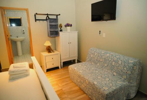 a living room with a couch and a chair and a television at Hostal 53 Boutique Santo Domingo in Santo Domingo