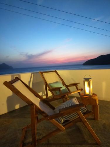a lounge chair with a candle and a table with a lamp at Amorgos Elegant Houses, Villa 3 in Aegiali