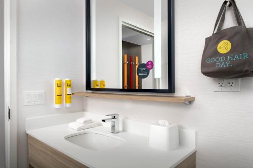a bathroom with a sink and a mirror at Tru By Hilton Charleston Ashley Phosphate, Sc in Charleston