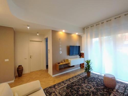 uma sala de estar com uma grande janela e uma televisão em La Dama dei Fiori em Vimercate