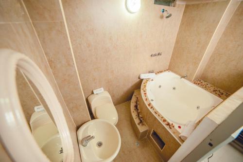 y baño con bañera, aseo y lavamanos. en Hotel Luxor Pucallpa, en Pucallpa