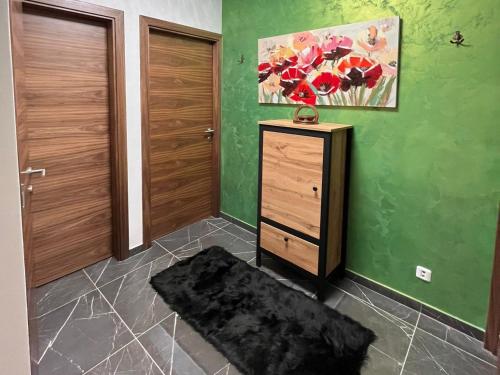 a room with a dresser and a green wall at Aby in Slavonski Brod
