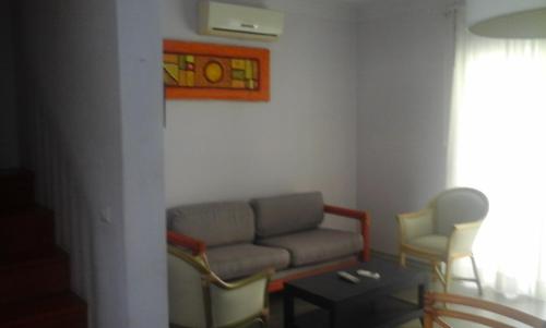 a living room with a couch and two chairs at Residencial Las Palmeras de Willy Boca Chica in Boca Chica