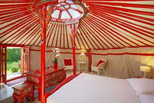 1 dormitorio con 1 cama en una tienda de circo en Yourte au Paradis, en Souvigné