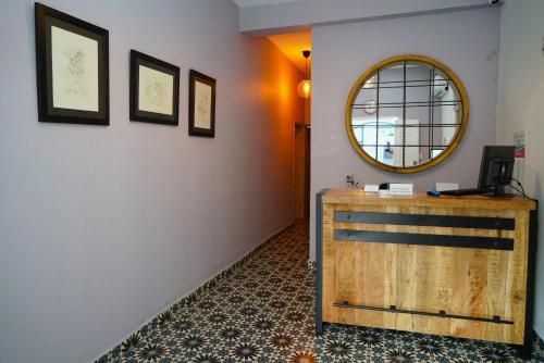 a hallway with a mirror and a wooden dresser at Hostal 53 Boutique Santo Domingo in Santo Domingo