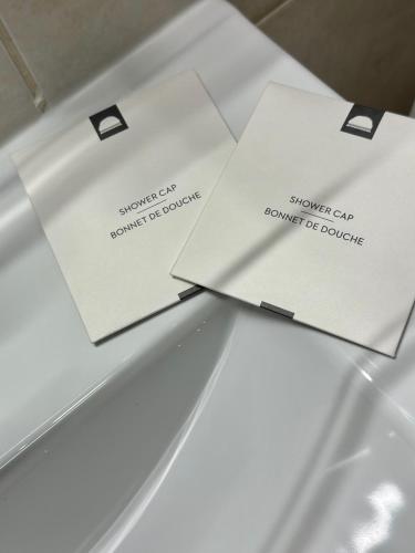 two white envelopes sitting on top of a table at Perle rare « Le Cosy de CDG » in Le Blanc-Mesnil