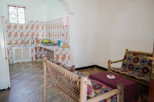 uma sala de estar com uma mesa e um sofá em MOYOWANGU HOUSE PAJE em Paje