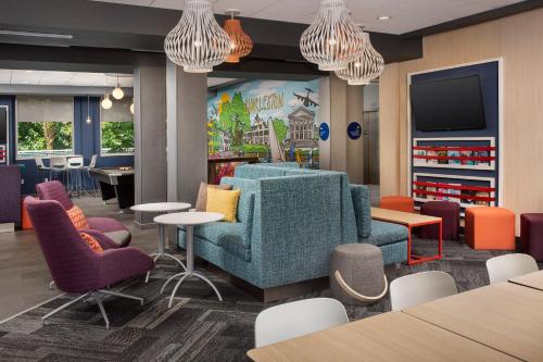 a waiting room with a couch and tables and chairs at Tru By Hilton Charleston Ashley Phosphate, Sc in Charleston