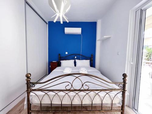 uma cama num quarto com uma parede azul em WSD Faliro New 1BD Apartment with Bal Near Alimos Marina em Atenas