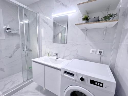 a white bathroom with a sink and a washing machine at WSD Faliro New 1BD Apartment with Bal Near Alimos Marina in Athens