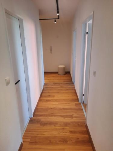 un pasillo vacío con paredes blancas y suelo de madera en Apartment by Bruno, en Innsbruck