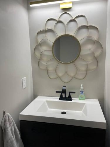 a bathroom with a sink and a mirror on the wall at New Stylish Condo Monthly Rental in Reminderville