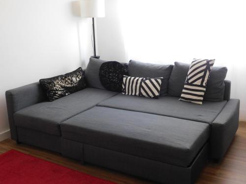un divano grigio con cuscini in soggiorno di Versilia Tonfano villetta a Marina di Pietrasanta