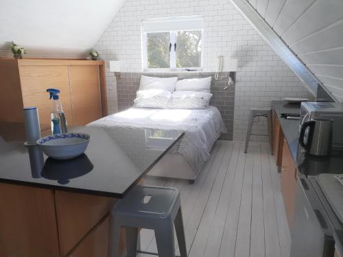 um pequeno quarto com uma cama e uma cozinha em Karsen residence em Cidade do Cabo