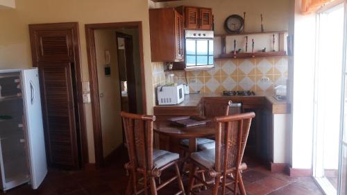 a kitchen with a table and chairs and a counter at Residencial Las Palmeras de Willy Boca Chica in Boca Chica