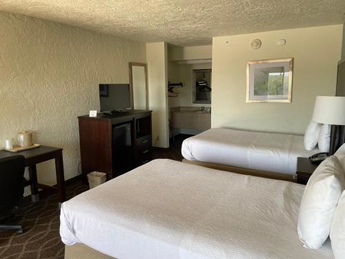 a hotel room with two beds and a television at Quality Inn Clinton North in Clinton