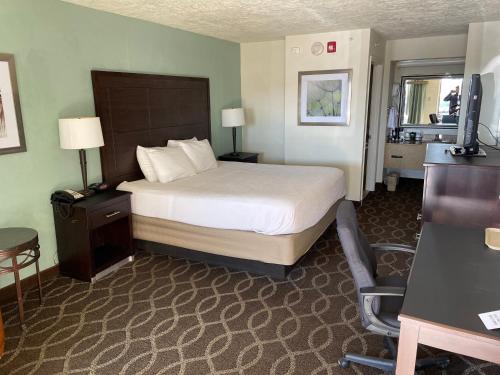 a hotel room with a bed and a desk and a chair at Quality Inn Clinton North in Clinton