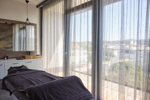 a bedroom with a large window with a view at Impulshotel FREIGOLD in Freistadt