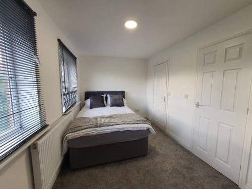 a bedroom with a bed in a room with windows at Perfect for family getaways in West Thurrock