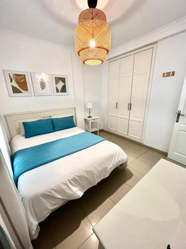 a bedroom with a large bed and a chandelier at COSTA AZUL APARTMENTS - 1C in Puerto de Mogán
