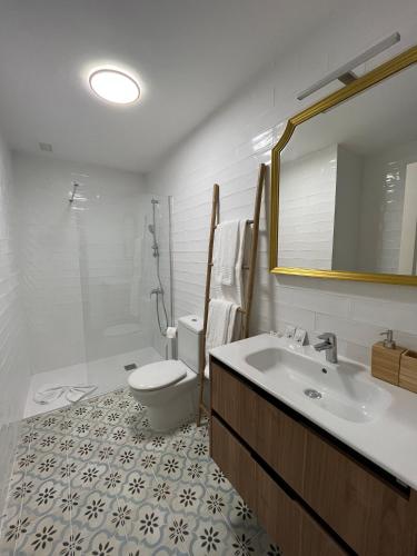 a bathroom with a sink and a toilet and a mirror at COSTA AZUL APARTMENTS - 1C in Puerto de Mogán