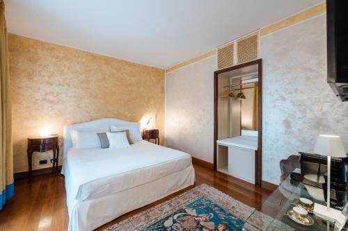 een slaapkamer met een wit bed en een televisie bij Airport BEA Rooms in Azzano San Paolo