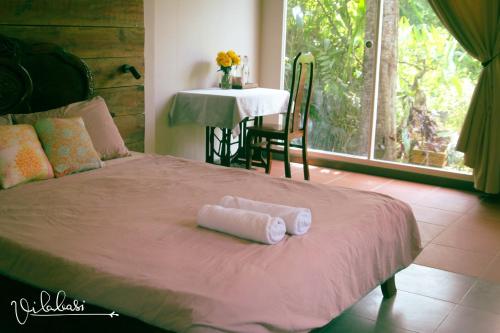 un letto con due asciugamani arrotolati sopra di Vila Basi a Nguyệt Hạng