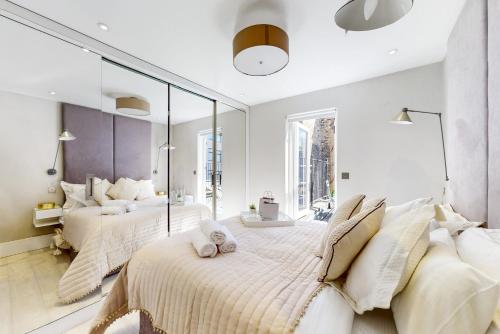 1 Schlafzimmer mit 2 Betten und einem großen Spiegel in der Unterkunft Park Lane Apartments Marylebone in London