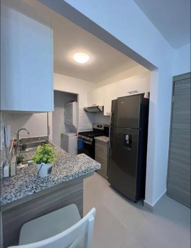 a kitchen with a black refrigerator and a counter at Sweet home in Punta Cana