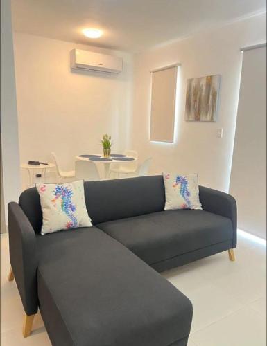 a black couch in a living room with a table at Sweet home in Punta Cana