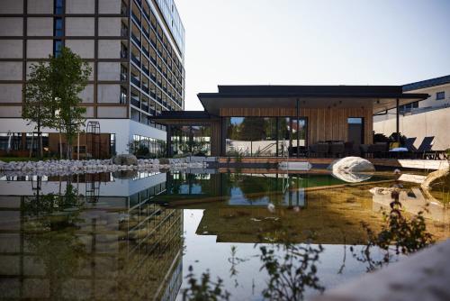 フライシュタットにあるImpulshotel FREIGOLDの水面の建物の反射