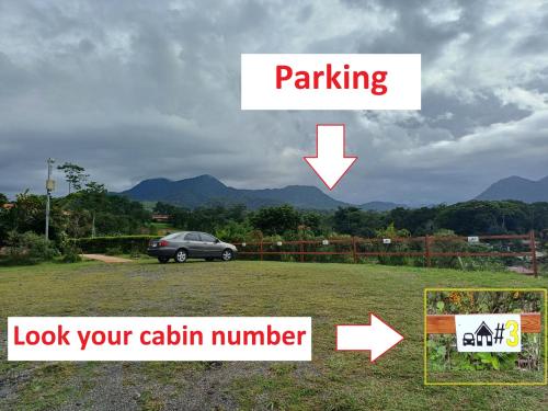 a car parked in a field with a car parking sign at Cabañas Sueños del Arenal in Fortuna