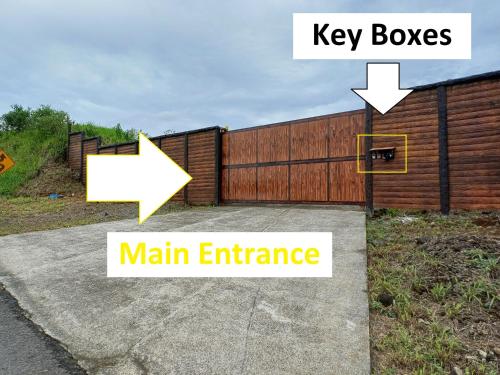a wooden fence with a key boxes and a main entrance at Cabañas Sueños del Arenal in Fortuna