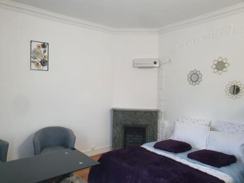 une chambre blanche avec un lit et une chaise dans l'établissement Studio/Bourget/CDG/Villepinte, à Aulnay-sous-Bois