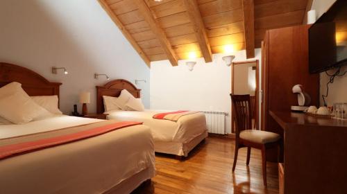 a hotel room with two beds and a television at Hotel Casa de Familia de San Cristobal in San Cristóbal de Las Casas