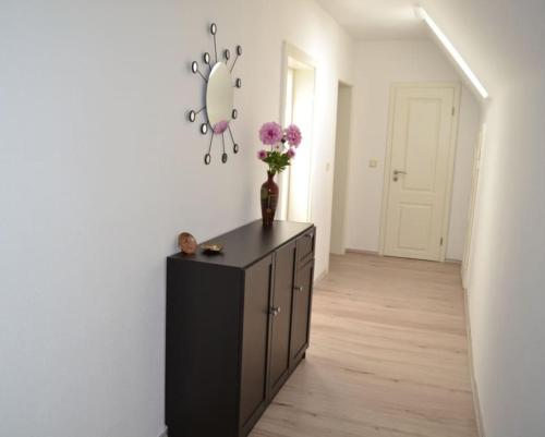a room with a black cabinet with a vase of flowers on it at Pension,Ferien, Monteurwohnung , Unterkunft,Zimmer in Schönebeck