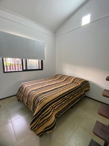 ein Schlafzimmer mit einem Bett in der Ecke eines Zimmers in der Unterkunft Alquiler temporal Colonia del Sacramento in Colonia del Sacramento