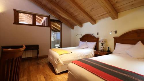 a bedroom with two beds and a window at Hotel Casa de Familia de San Cristobal in San Cristóbal de Las Casas