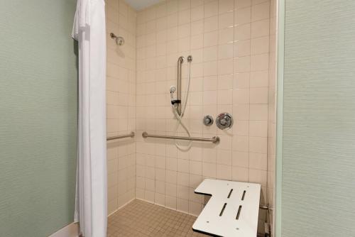 a bathroom with a shower with a bench in it at Homewood Suites Grand Rapids in Grand Rapids