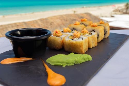 a plate of food on a table next to a cup at Wyndham Grand Cancun All Inclusive Resort & Villas in Cancún